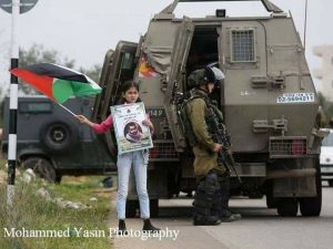 Child waving flag in Bil'in (image by Mohammad Yassin)