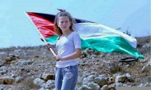 Ahed holding the Palestinian flag at a protest