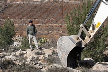 Israeli bulldozer with settler standing nearby (Maan)