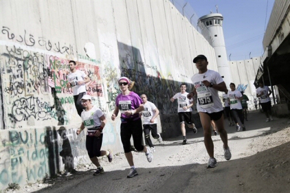 Runners take part in the 2015 Palestine Marathon, skirting Israel's separation wall to the north of Bethlehem. (Right to Movement/Signe Vest)