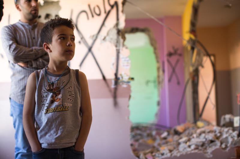 Child stands in home demolished by Israeli army (image by vozisneias.com)