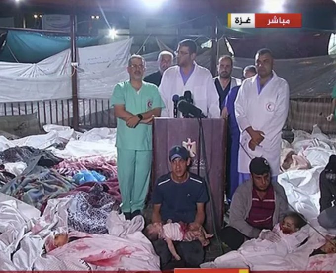 Doctors gather for a press conference amidst the bodies of the people killed