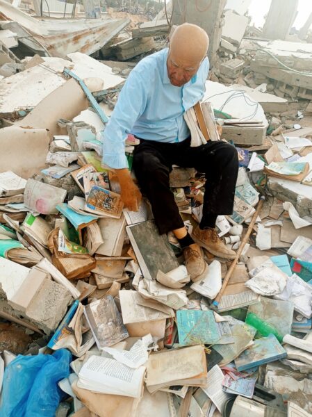 Dr. Fayez Abu Shamala surrounded by his torn books and the rubble of his home destroyed by an Israeli airstrike (June 14)