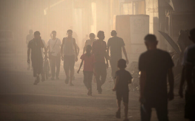 Palestinians trying to flee Khan Younis in the midst of smoke from Israeli bombardment